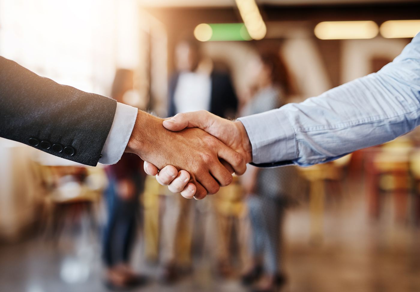 Two people shaking hands in a workplace